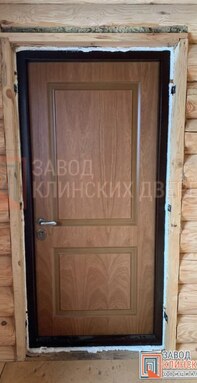 внутренний вид входной металлической двери с отделкой мдф в доме из оцилиндрованного бревна