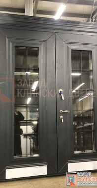 двухстворчатая входная дверь темного цвета с полноразмерными стеклопакетами и ковкой