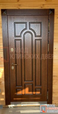 установленная входная дверь в деревянном доме из бруса