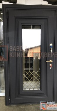 черная входная дверь с зеркальным стеклом и изящной внутренней кованой решеткой